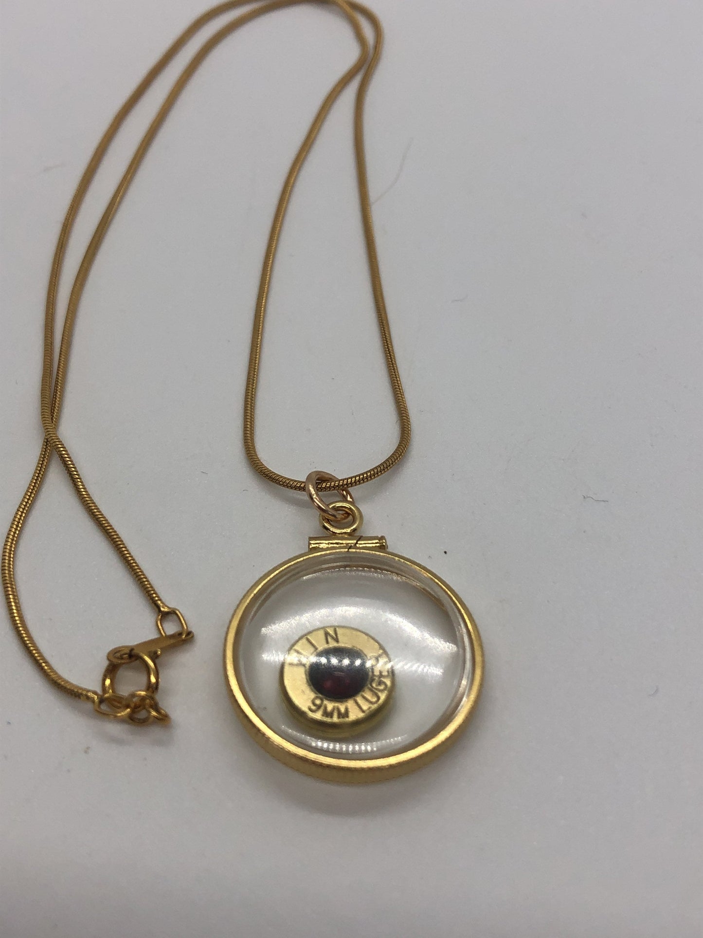9mm bullet necklace, back to back view locket, 14k gold filled one side fired primer, other Garnet gem