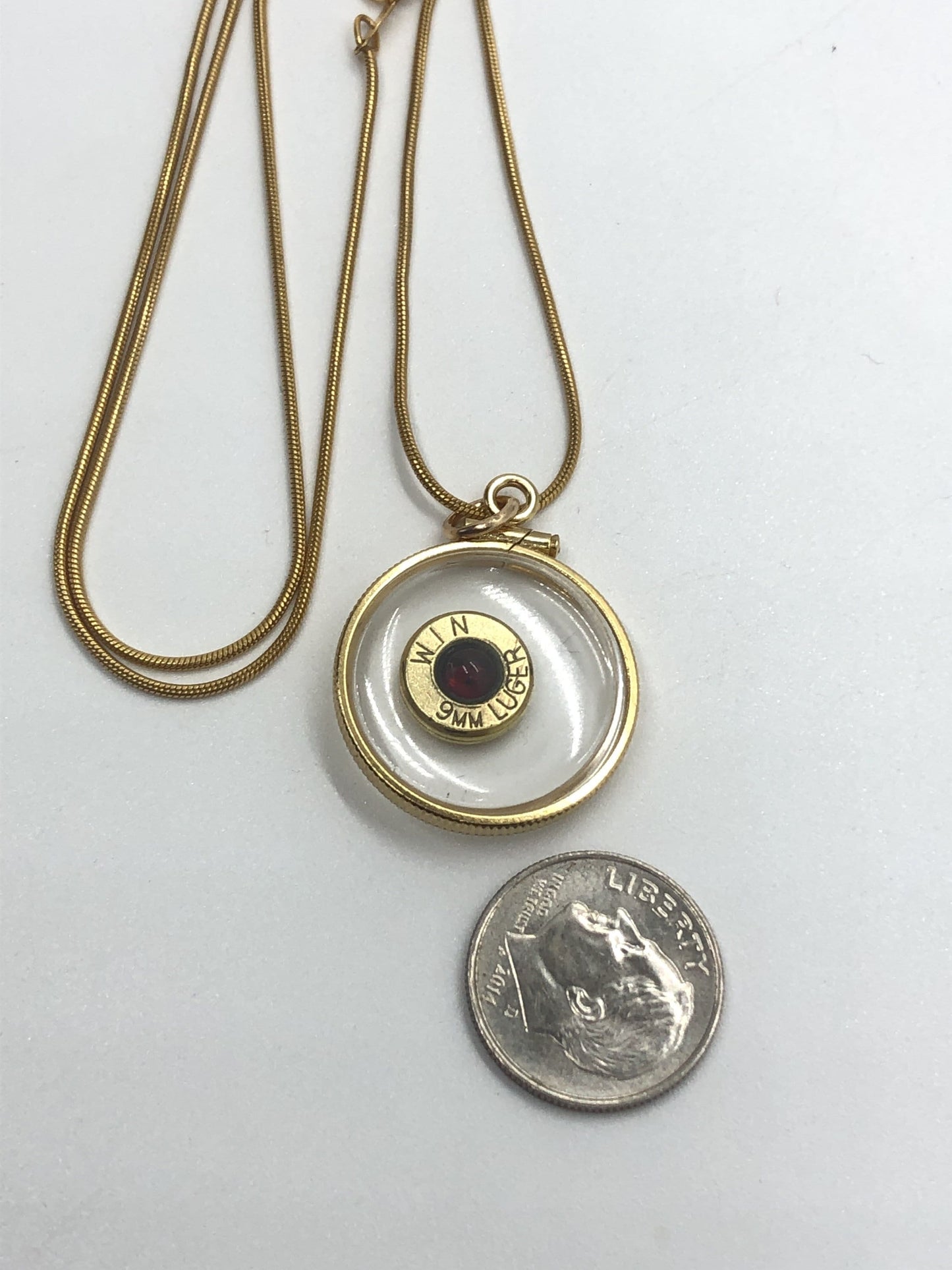 9mm bullet necklace, back to back view locket, 14k gold filled one side fired primer, other Garnet gem