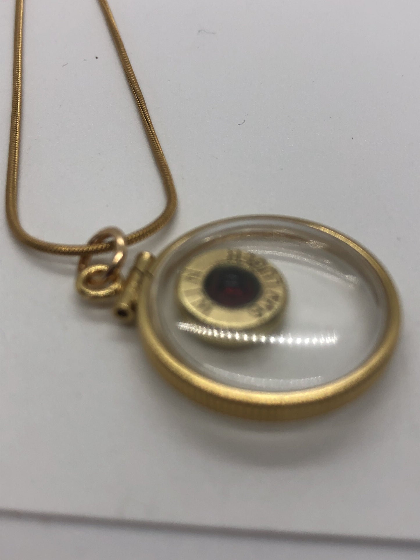 9mm bullet necklace, back to back view locket, 14k gold filled one side fired primer, other Garnet gem