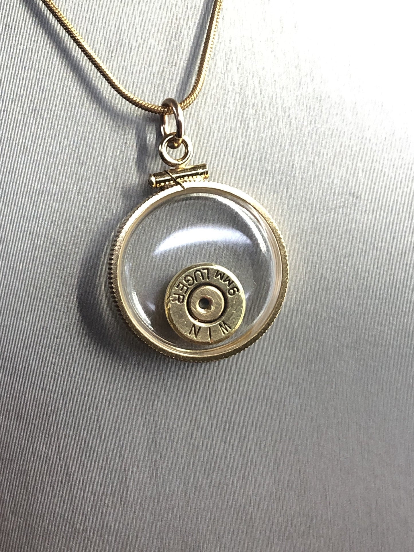 9mm bullet necklace, back to back view locket, 14k gold filled one side fired primer, other Garnet gem