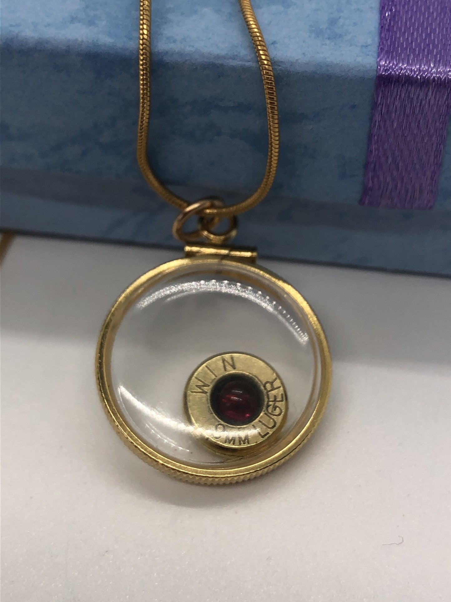 9mm bullet necklace, back to back view locket, 14k gold filled one side fired primer, other Garnet gem