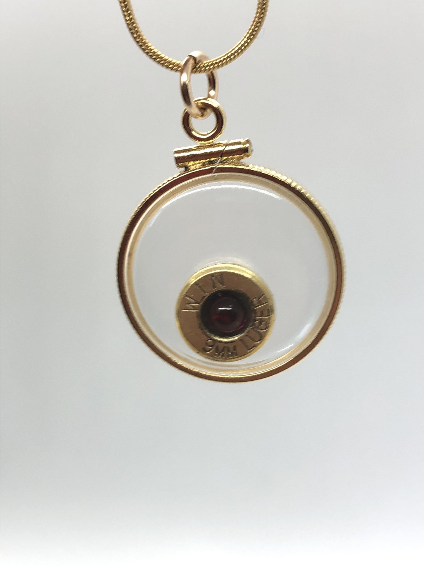 9mm bullet necklace, back to back view locket, 14k gold filled one side fired primer, other Garnet gem