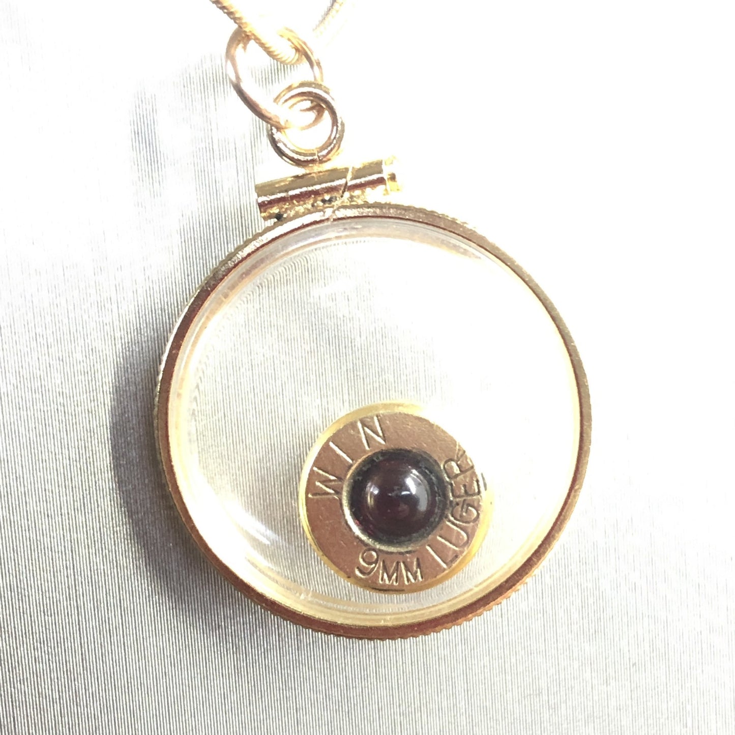 9mm bullet necklace, back to back view locket, 14k gold filled one side fired primer, other Garnet gem