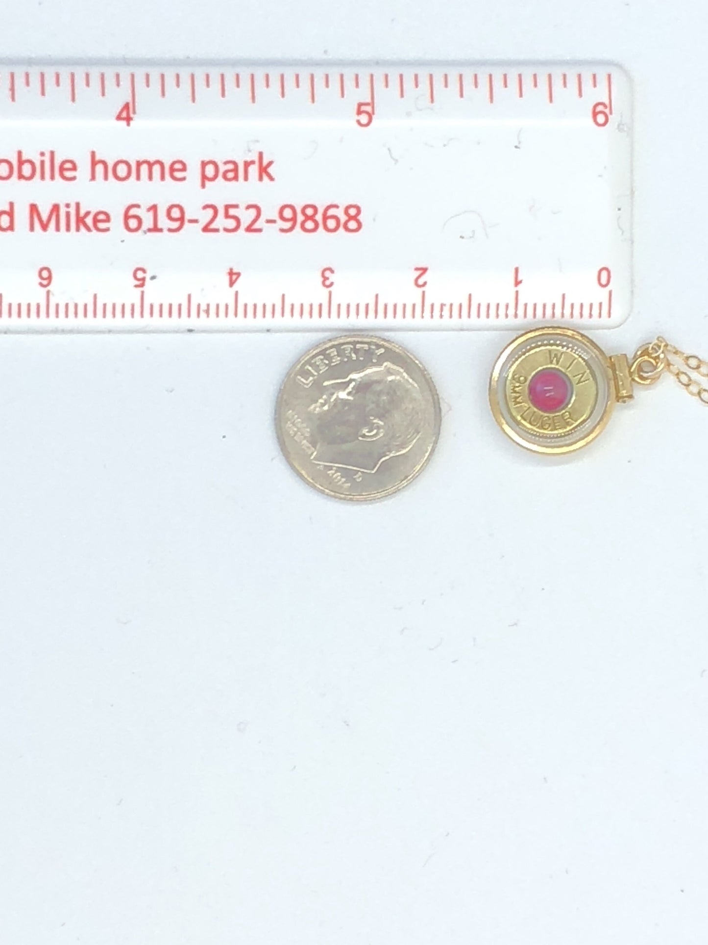 Handmade 14k gold filled .223 cal bullet view locket, finished with a 4mm genuine garnet gemstone, view from both sides