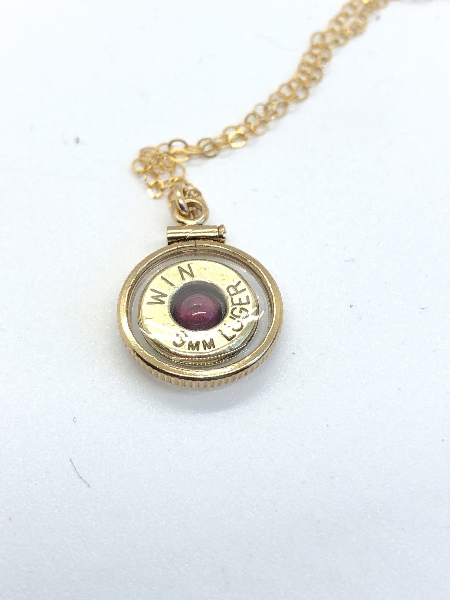 Handmade 14k gold filled 9mm bullet view locket, finished with a 4mm genuine garnet gemstone, view from both sides