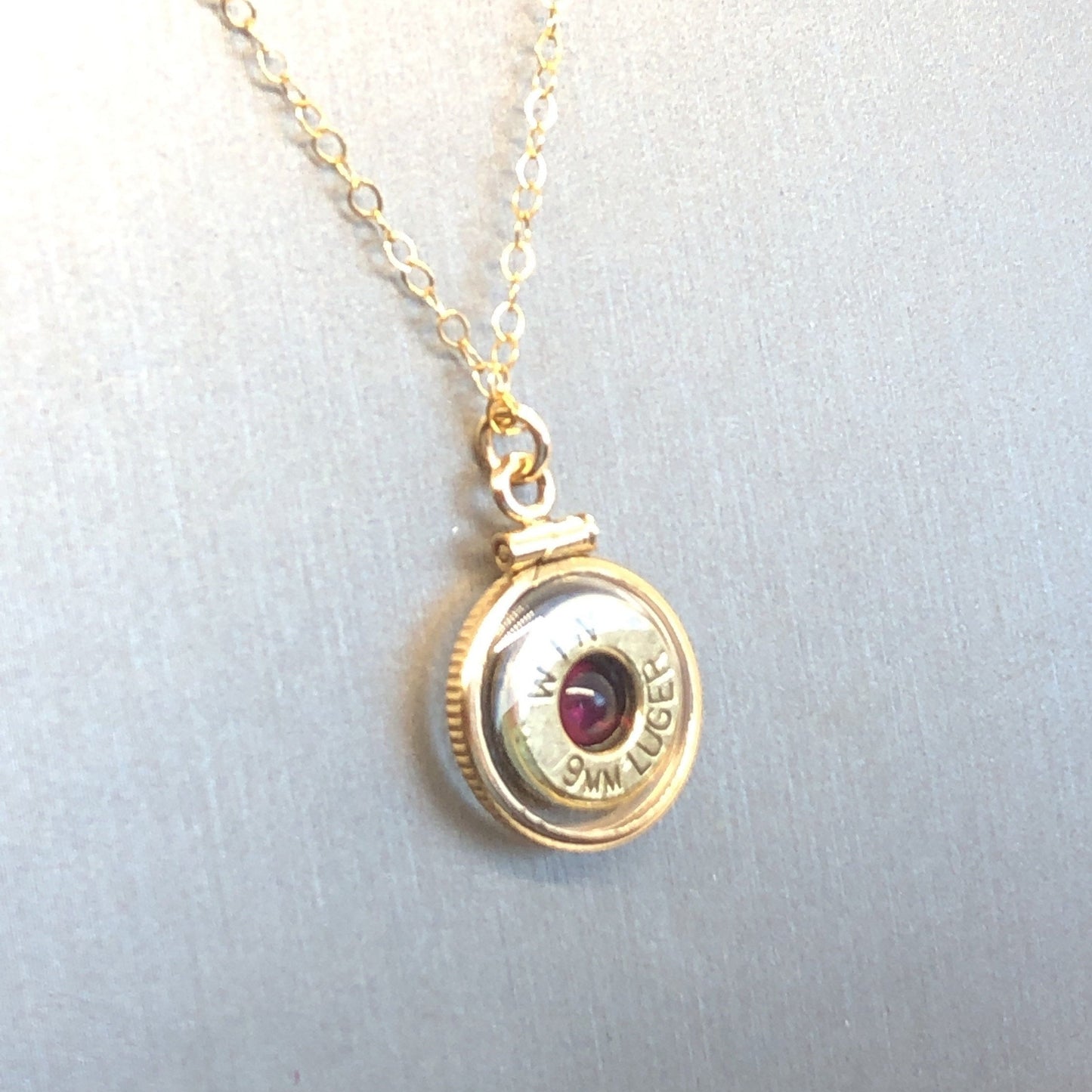 Handmade 14k gold filled 9mm bullet view locket, finished with a 4mm genuine garnet gemstone, view from both sides